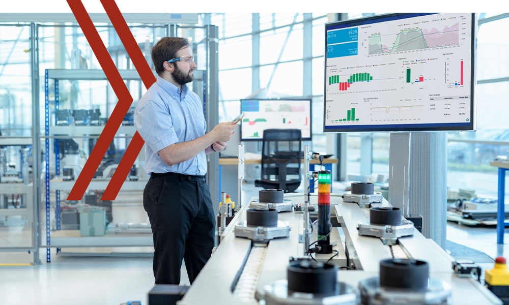 Mann in Halle steht vor einem Bildschirm